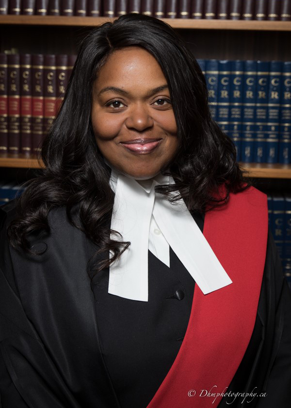 Portrait of Hon. Justice Marlyse Dumel with a bookshelf background